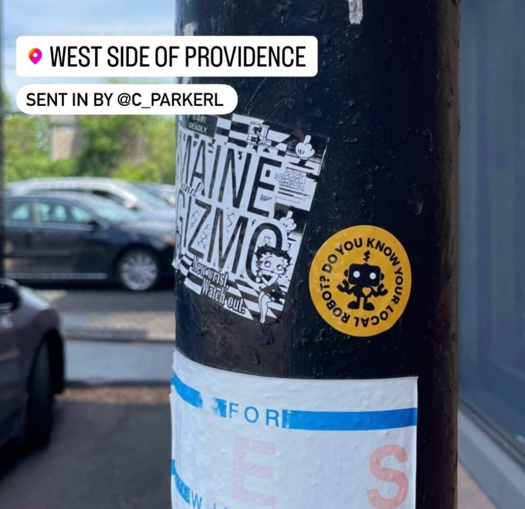 Stickers on a pole reading "Do You Know Your Local Robot?"