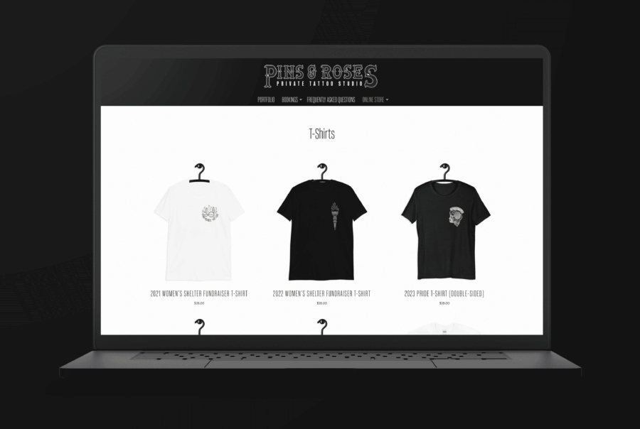 Tattoo artist website showing Pins & Roses Women's Shelter fundraiser tees and Pride T-shirt