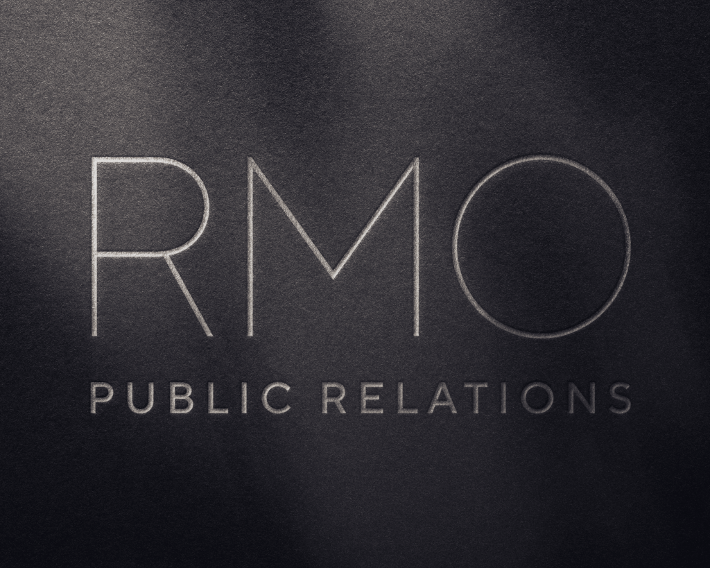 Custom embossed RMO Public Relations logo on a dark, textured background.